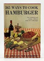 Front cover view of the hardcover cookbook '365 Ways to Cook Hamburger' showing ground hamburger meat and food items on a wooden cutting board with a bottle of wine, mushrooms, onions, and herbs.