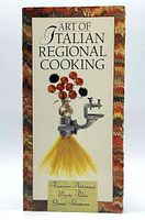 Front cover of the Art of Italian Regional Cooking softcover book showing the title, authors, and unique pasta and tomato sculpture illustration.