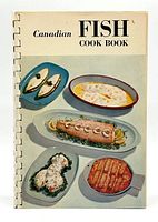 Front cover of Canadian Fish Cook Book showing fish dishes on platters.