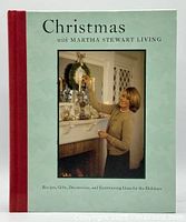 Front cover of the hardcover book with Martha Stewart arranging Christmas decorations above a fireplace mantel.