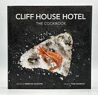 Front cover of the Cliff House Hotel cookbook showing a seafood dish with prawn and salt crust on a black background.