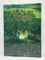Front cover of the cookbook showing a green forest landscape with a castle, title in gold lettering.