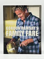 Front cover of the Gordon Ramsay Family Fare cookbook showing Gordon Ramsay in a plaid shirt mixing ingredients.