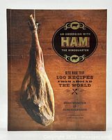 Front cover of the cookbook showing the title, authors, and an image of a hanging cured ham.