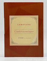 Front cover of brown softcover book with cream box and title 'Larousse Gastronomique Fish & Seafood'.