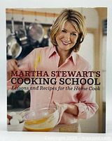 Front cover of the hardcover book showing Martha Stewart in a kitchen setting, mixing ingredients in a glass bowl.