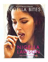 Front cover of the Nigella Bites cookbook showing Nigella Lawson tasting food, with full title and author name visible.