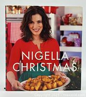 Front cover photo showing woman with dark hair in red and green outfit holding a plate of cooked chicken, title 'Nigella Christmas' in white text.