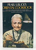 Front cover image of Pearl S. Buck's Oriental Cookbook showing a portrait of Pearl S. Buck holding chopsticks and a bowl.