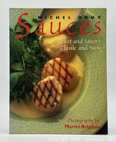 Front cover of Michel Roux's cookbook 'Sauces: Sweet and Savory Classic and New' showing grilled scallops with creamy sauce and greens.