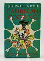 Front cover of hardcover book titled 'The Complete Book of Caribbean Cooking' with colorful Caribbean-themed illustration and author name Elisabeth Lambert Ortiz.