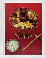 Front cover of cookbook showing traditional Chinese hot pot, bowl of rice, and chopsticks on a red background.