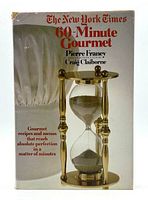Front cover of The New York Times 60-Minute Gourmet cookbook featuring an hourglass illustration and text.