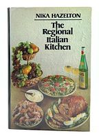 Front cover of the hardcover cookbook with Italian dishes and wine bottle image.