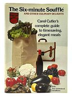 Front cover of the first edition hardcover book 'The Six-Minute Soufflé and Other Culinary Delights' by Carol Cutler showing fresh vegetables, a bottle, and a paper grocery bag.