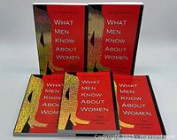 Front view of five softcover notebooks with red covers titled 'What Men Know About Women' by Dr Nada Zilch, arranged standing and lying flat.
