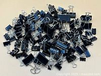 pile of mixed-size black binder clips