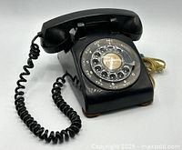 Three-quarter view showing full phone with coiled cord