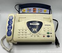 Front view of Brother FAX-565 fax machine showing handset, keypad and display