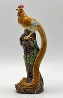 front view of ceramic rooster on tree trunk