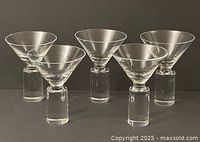 Five clear glass martini glasses grouped front view