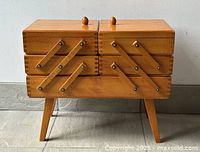 Basket closed front view showing legs, dovetail joints, swing arms