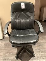 Front view of black office chair showing padded backrest and armrests