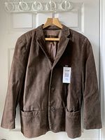 Front view of brown Danier leather jacket hanging on a wooden hanger, showing button front closure and two front pockets.