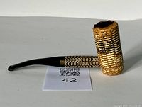 Side view of vintage corncob pipe showing textured natural bowl and patterned metal band with black mouthpiece