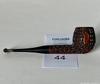 Side view of the pipe showing textured wood bowl with smooth oval section and black stem.
