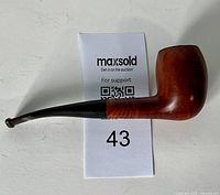Side view of vintage wooden tobacco pipe showing entire pipe with bowl and black stem