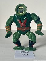 Front view of vintage MOTU Leech action figure showing green muscular body, circular mouth head, brown belt, and suction cup hands and feet.