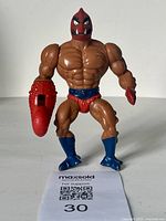Front view of vintage 1980s Masters of the Universe Clawful action figure showing muscular body, red claw, and blue boots.