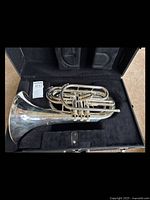 Full view of silver baritone brass instrument inside black plush-lined case in good condition.