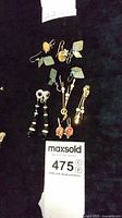 Overall view of six pairs of clip-on and dangle earrings on black cloth background.
