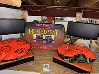 Two Lava Buns Plus microwavable heated seat cushions on a wooden surface with product box behind.