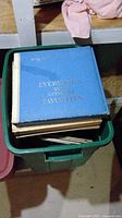 Photo showing a green plastic bin filled with vinyl LP records, top album is a blue album titled 'EVERYONE'S TOP COUNTRY FAVORITES'