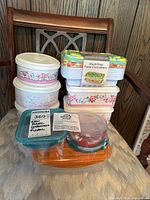 Stack of multiple reusable food containers on chair with various floral and colorful designs.