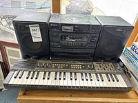 Full view of Sony CFD-560 stereo with two speakers and Casio Casiotone MT-100 keyboard in front.