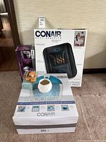 Full lot of spa-related items including Conair back massager, foot spa, Lenox candle holder with votives and tea lights displayed on carpet.