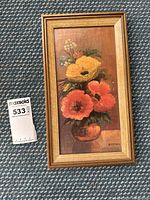 Framed oil painting showing a bouquet of orange and yellow poppies in a vase, signed by A. Corona on bottom right. The painting is vertical and the frame is gold toned wood.