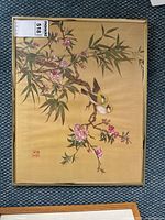 Frontal view of vintage Asian-style painting showing two birds on a blossoming branch with a signature stamp in the lower left corner.