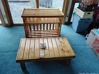 Wood coffee table and shelving unit positioned near glass doors on blue carpet, showing overall size and structure.