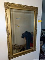 Full view of rectangular wall mirror with gold ornate frame showing overall condition and size.