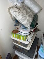 Stack of plastic and metal containers holding quilting supplies including batting and fabrics