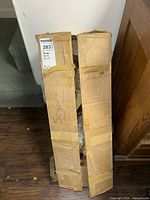 Closed cardboard box labeled 'Scapes' with visible wear and tape securing it.