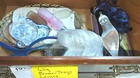 Drawer containing white wig, small perfume bottles, blue and white china dishes, mirrored dresser trays.
