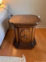Pair of vintage Drexel Heritage Marchesa side tables photographed from front showing decorative door and wood grain top.