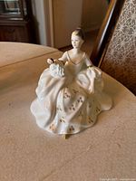 Front and angled views of Royal Doulton 'My Love' porcelain figurine showing detailed dress, gold accents, and red heart held by the figure.