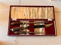 Carving set laid out in original open red box with satin interior.